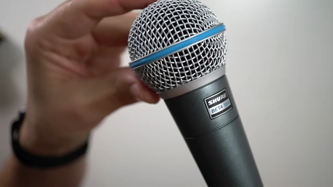Shure Beta 58A in der Hand, Gesamtansicht mit Korb und Griff